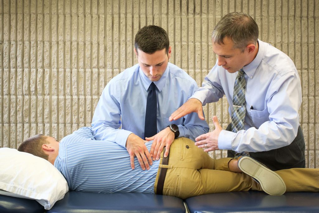 A physical therapist guides a DPT student in the care of a patient