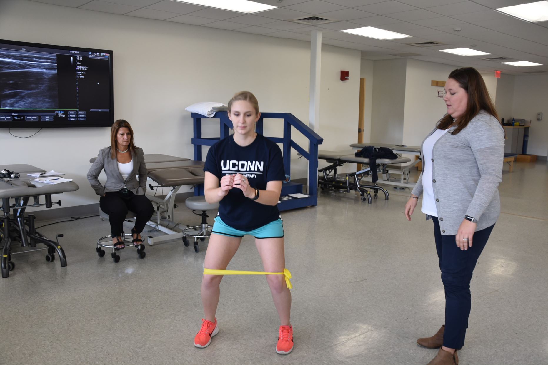 demonstrating a physical therapy exercise with faculty supervision
